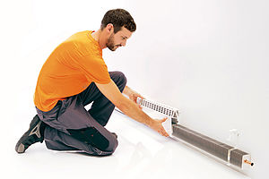 Variotherm Heizleisten können einfach und rasch durchgeführt werden: Die Halter an die Wand schrauben, die Heizelemente einlegen und anschließen. Verkleidung anbringen.